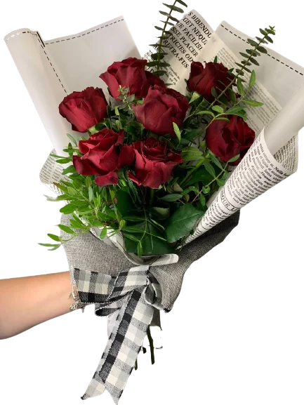 Romantyczny bukiet czerwonych róż owinięty w papier gazetowy