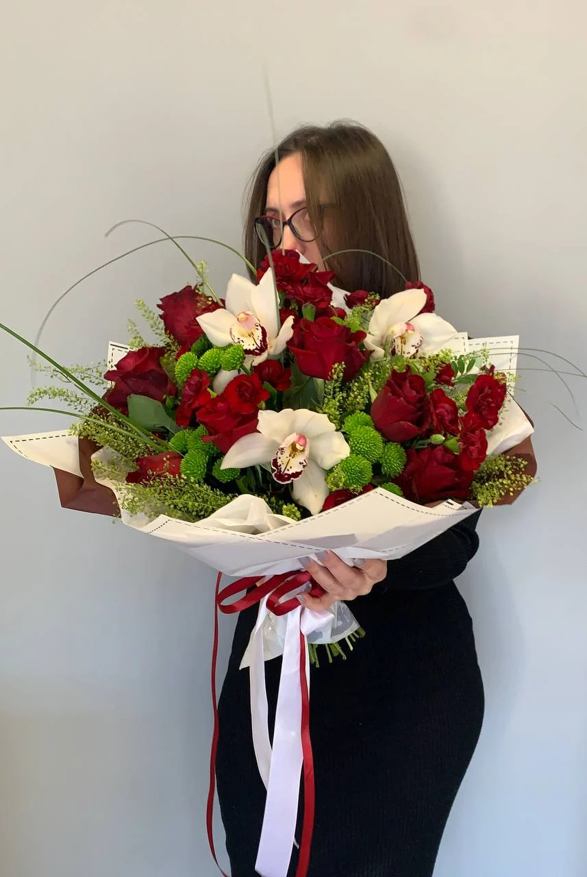 Bukiet z róż i białych orchidei z zielenią dekoracyjną, przewiązany wstążką