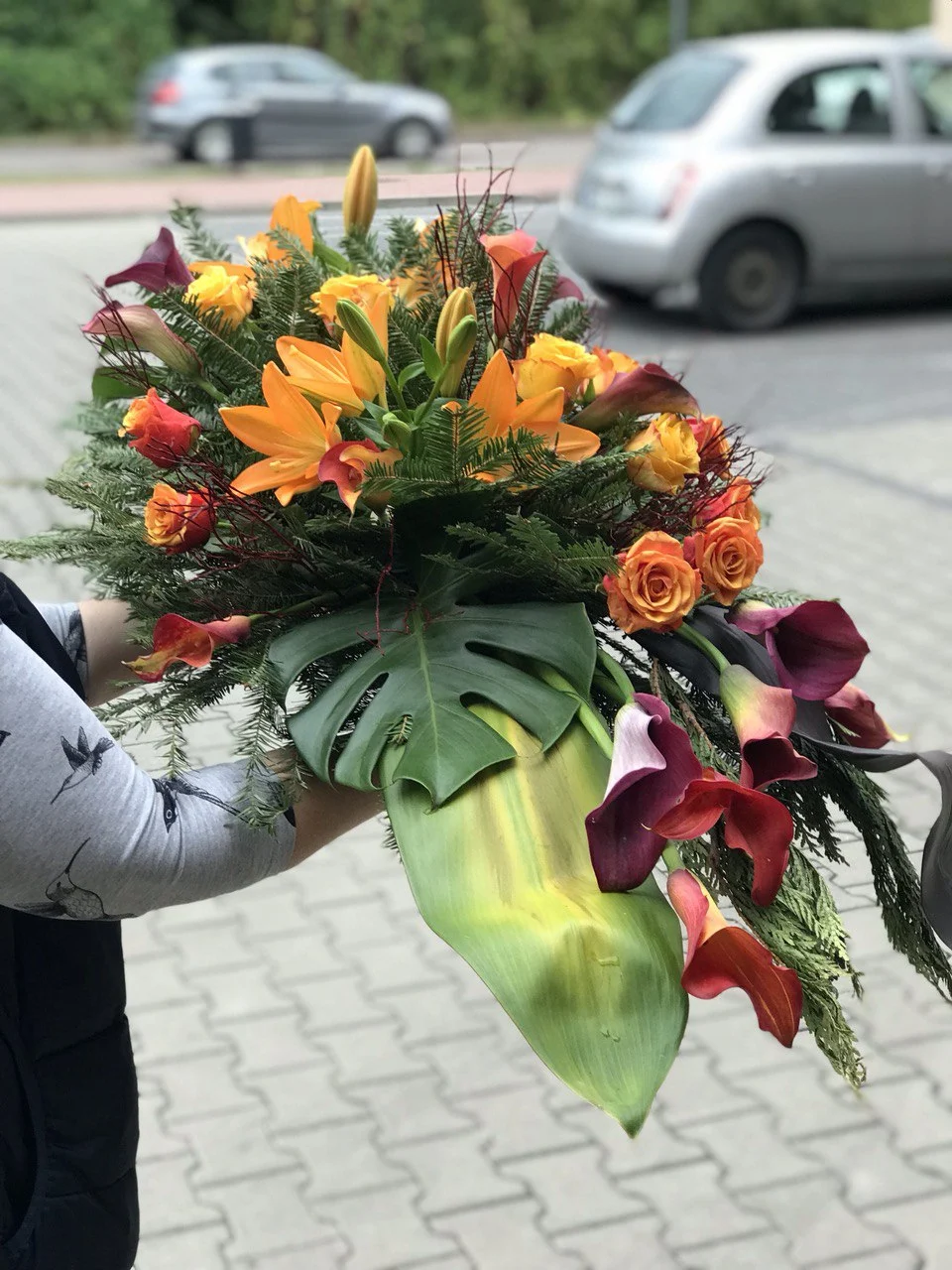 Wieńiec pogrzebowy z pomarańczowymi różami i liliami