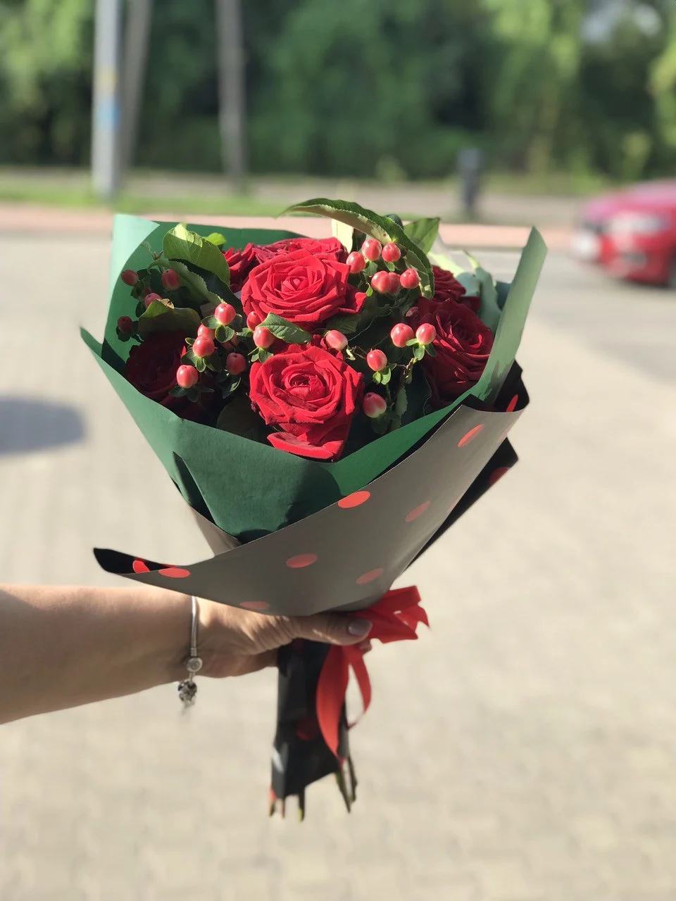 Kompozycja bukietu róż z ozdobnymi gałązkami