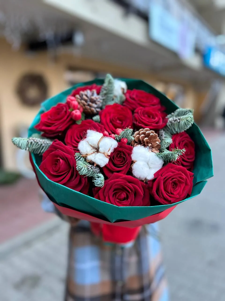 Bukiet róż w stylu bożonarodzeniowym z czerwonymi różami i leśnymi ozdobami