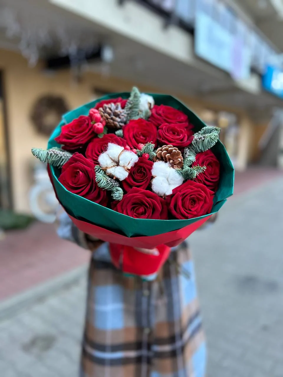 Bukiet róż z czerwonymi różami i dekoracją w stylu zimowym — szyszki, bawełna, jodła