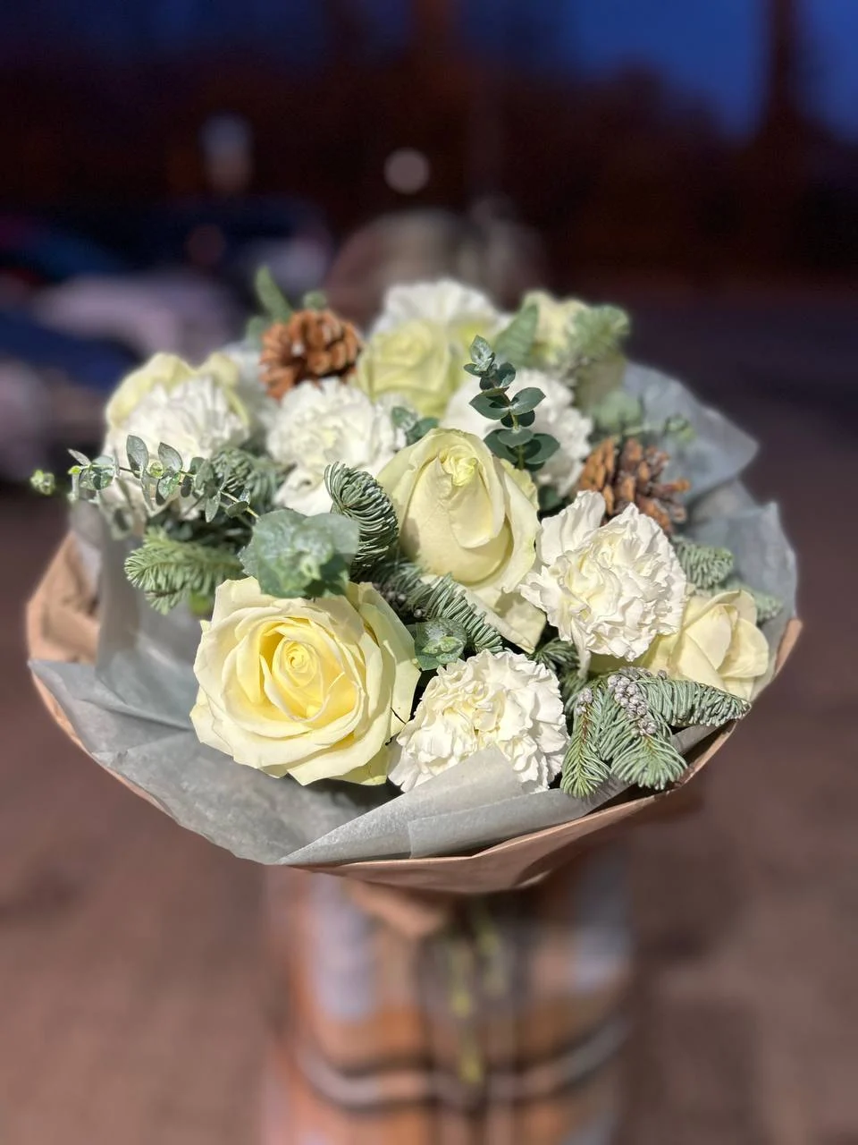 Bukiet z białych róż z dodatkiem szyszek i igliwia na zimę