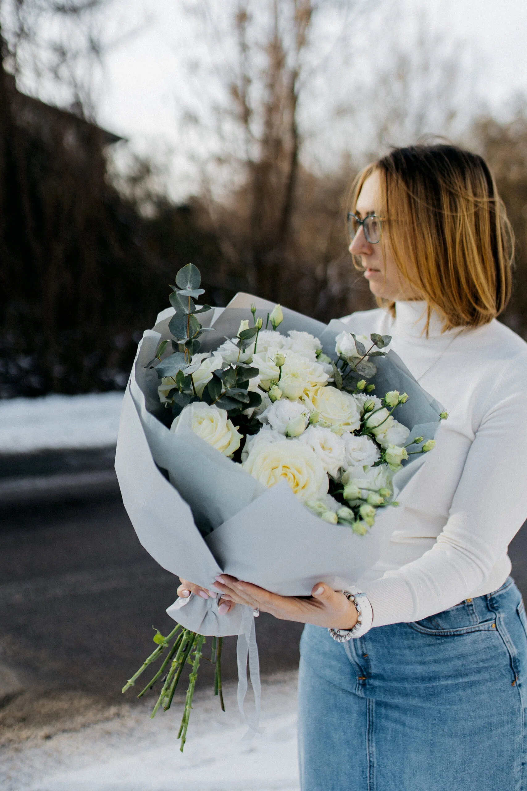 Bukiet białych róż z zielonymi gałązkami – naturalna i elegancka kompozycja