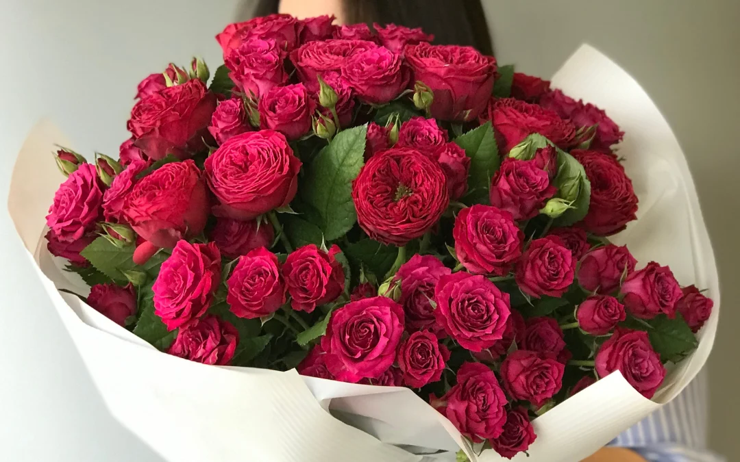 Duży bukiet jaskrawych róż w papierowej oprawie