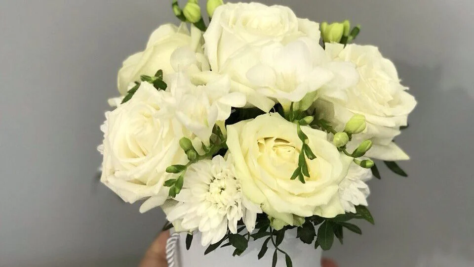 Białe róże i białe chryzantemy w eleganckiej pudełkowej kompozycji