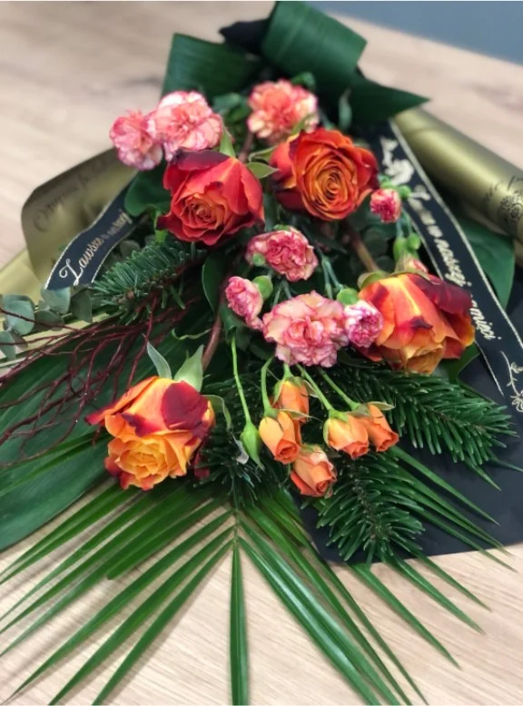 Bukiet pogrzebowy z pomarańczowych róż i goździków z zielenią dekoracyjną