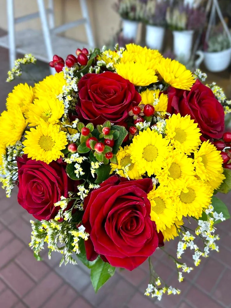 Kolorowy bukiet z czerwonej róży, margaretek i hiperikum