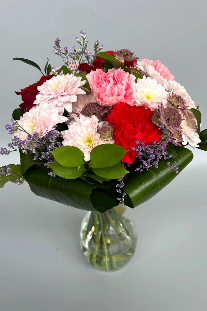 Pstry bukiet — kwiaty w wazonie w żywej kolorystyce