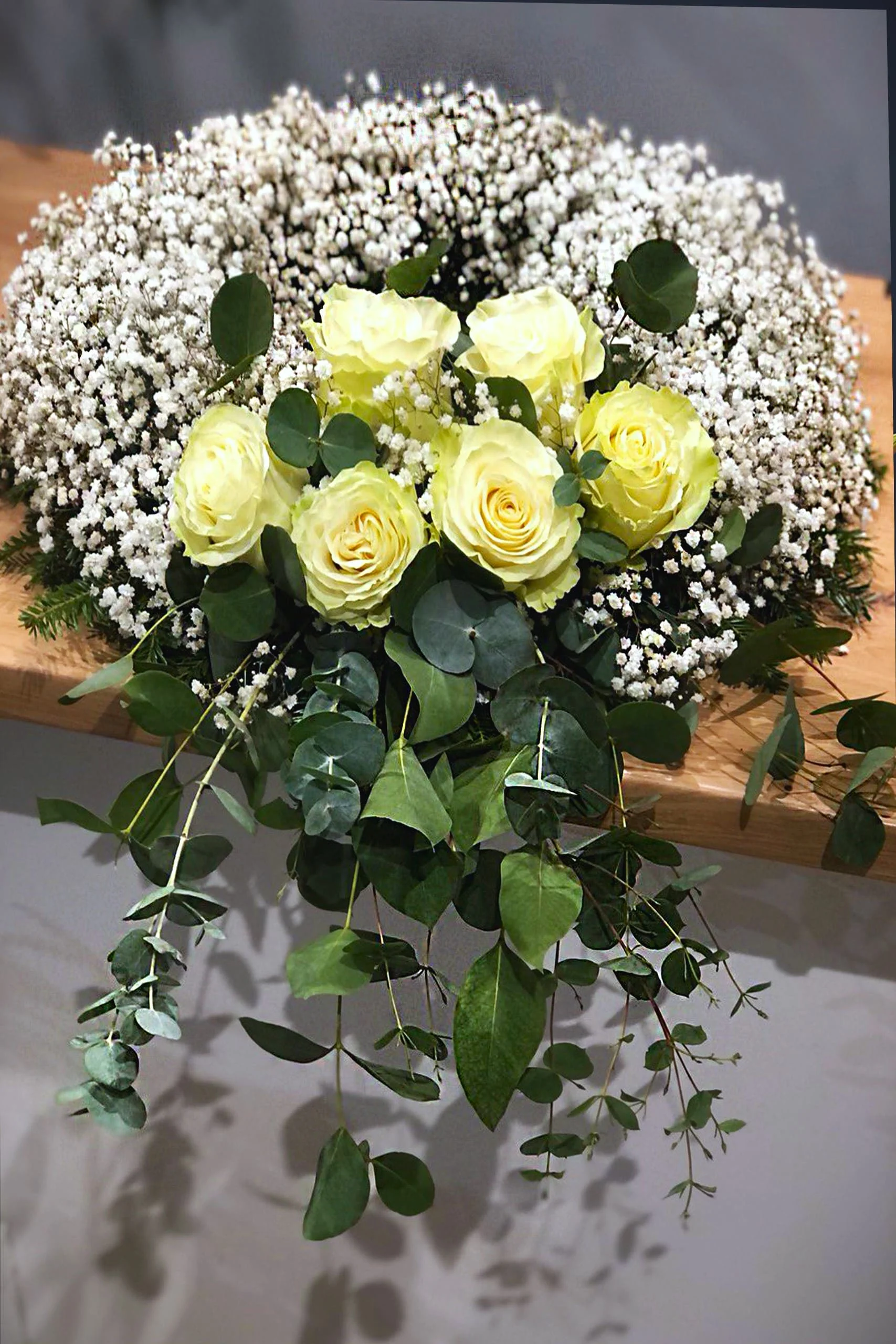 Stonowana wiązanka na pogrzeb z różami, jodłą i gipsówką