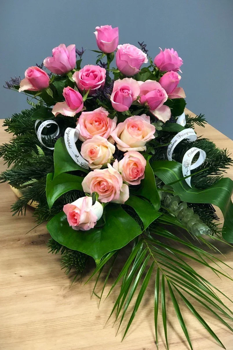 Stonowana kompozycja pogrzebowa z różowymi różami i monsterą