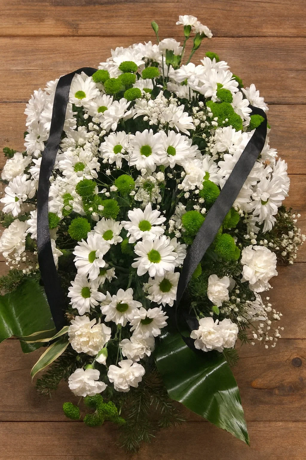 Nowoczesna biała wiązanka pogrzebowa z zielenią i margaretkami